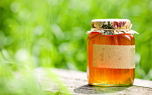 focus photography of jar of honey
